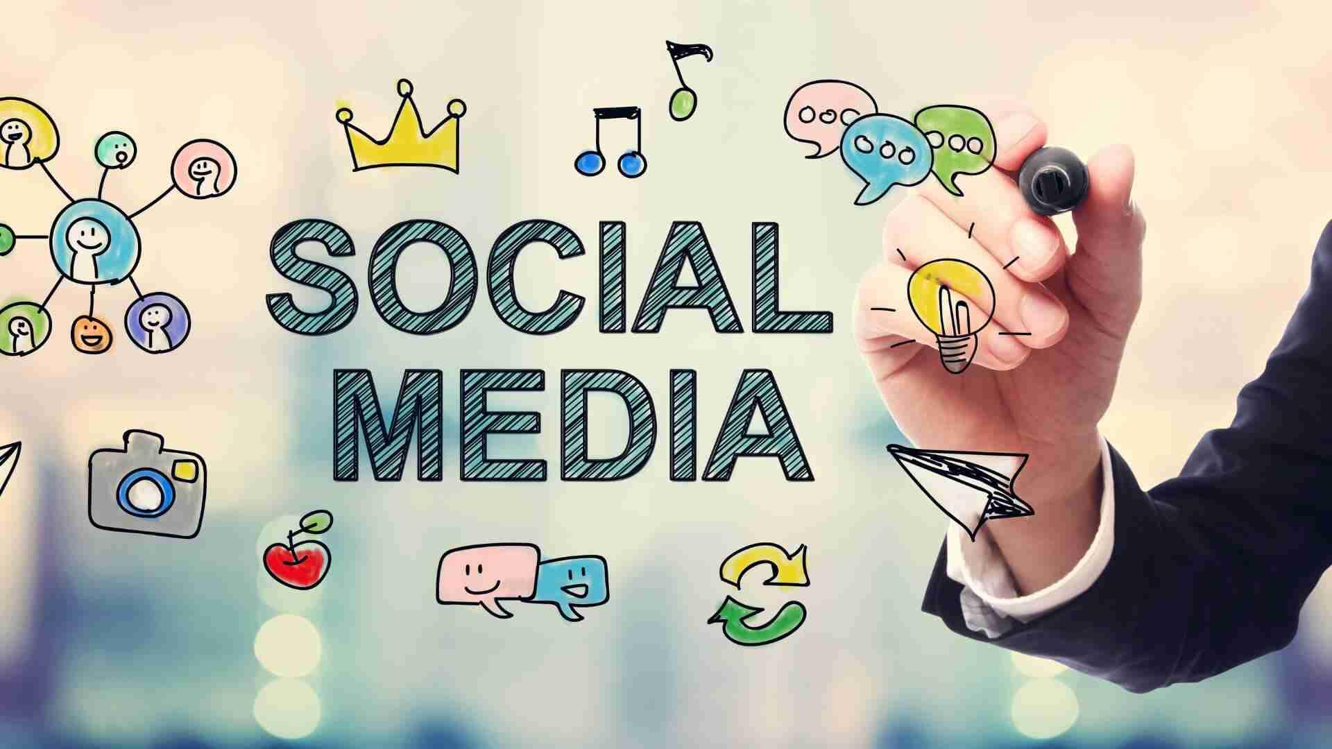 Hand, die mit einem Marker den Text 'Social Media' und verschiedene Symbole zeichnet.