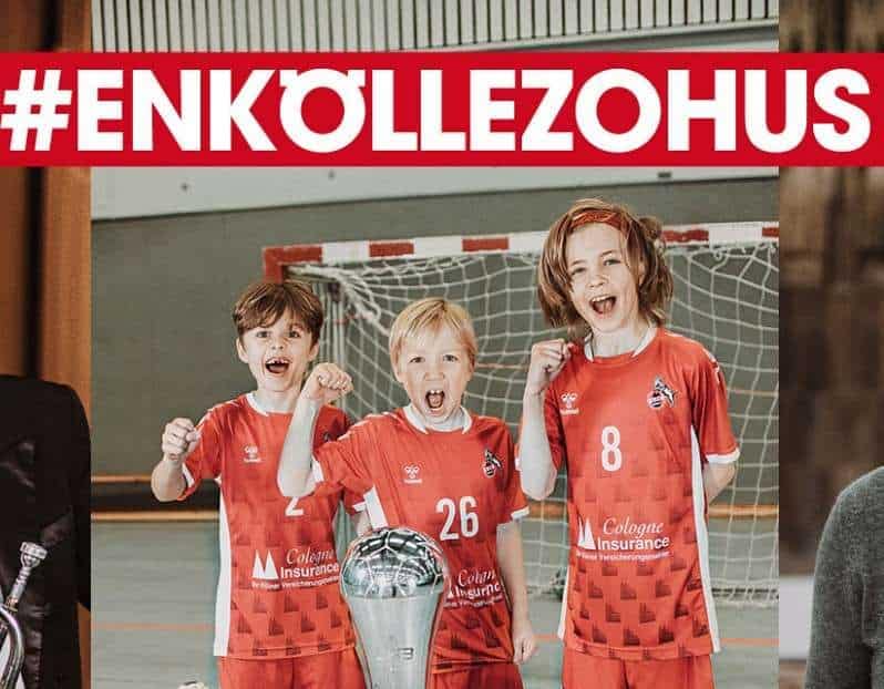 Drei Kinder in Handballtrikots posieren jubelnd mit einem Pokal in der Hand.