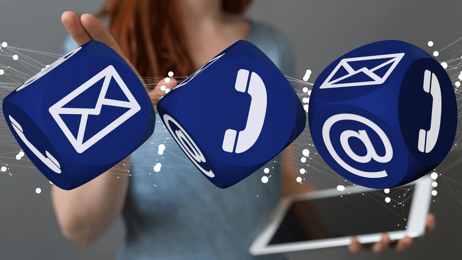 Drei blaue Würfel mit Symbolen für E-Mail, Telefon und Kontakt auf einem grauen Hintergrund.