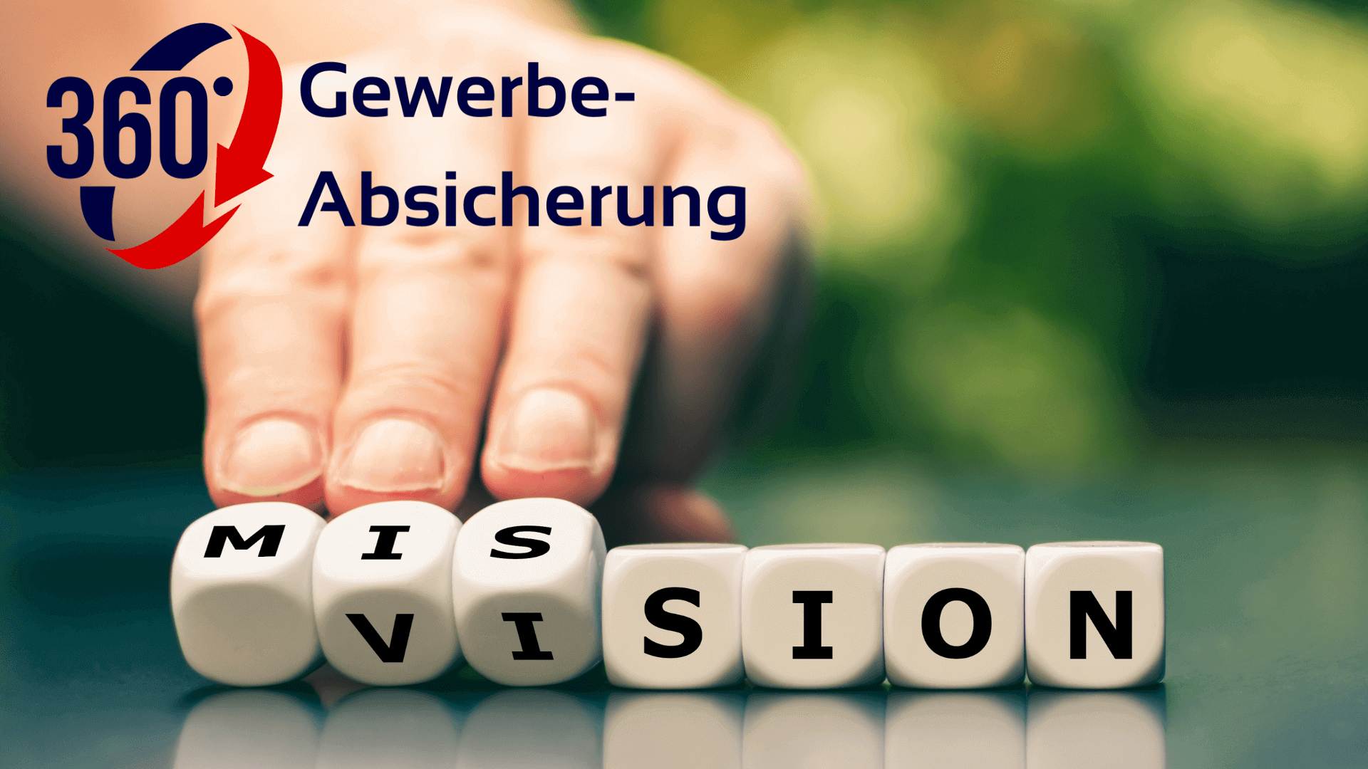 Hand, die Würfel mit den Buchstaben M, I, S, V, I, O, N anordnet, auf einem Tisch.