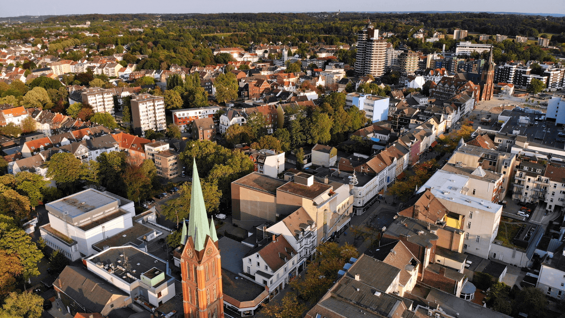 Luftaufnahme einer Stadt mit einem markanten Kirchturm und Wohngebäuden in Herne.