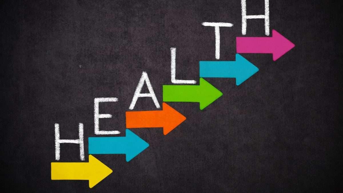 Das Wort Gesundheit in weißen Buchstaben mit bunten Pfeilen in verschiedenen Farben auf einem dunklen Hintergrund.
