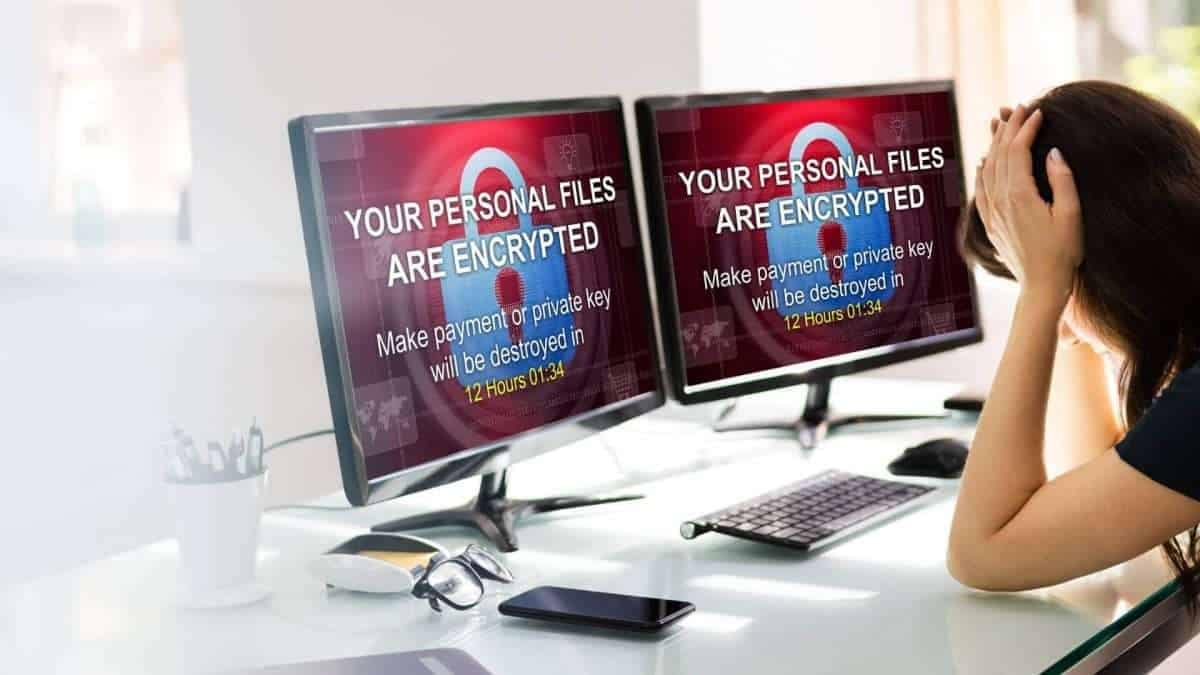 Zwei Computerbildschirme zeigen eine Ransomware-Warnung mit der Aufschrift 'Ihre persönlichen Dateien sind verschlüsselt'.