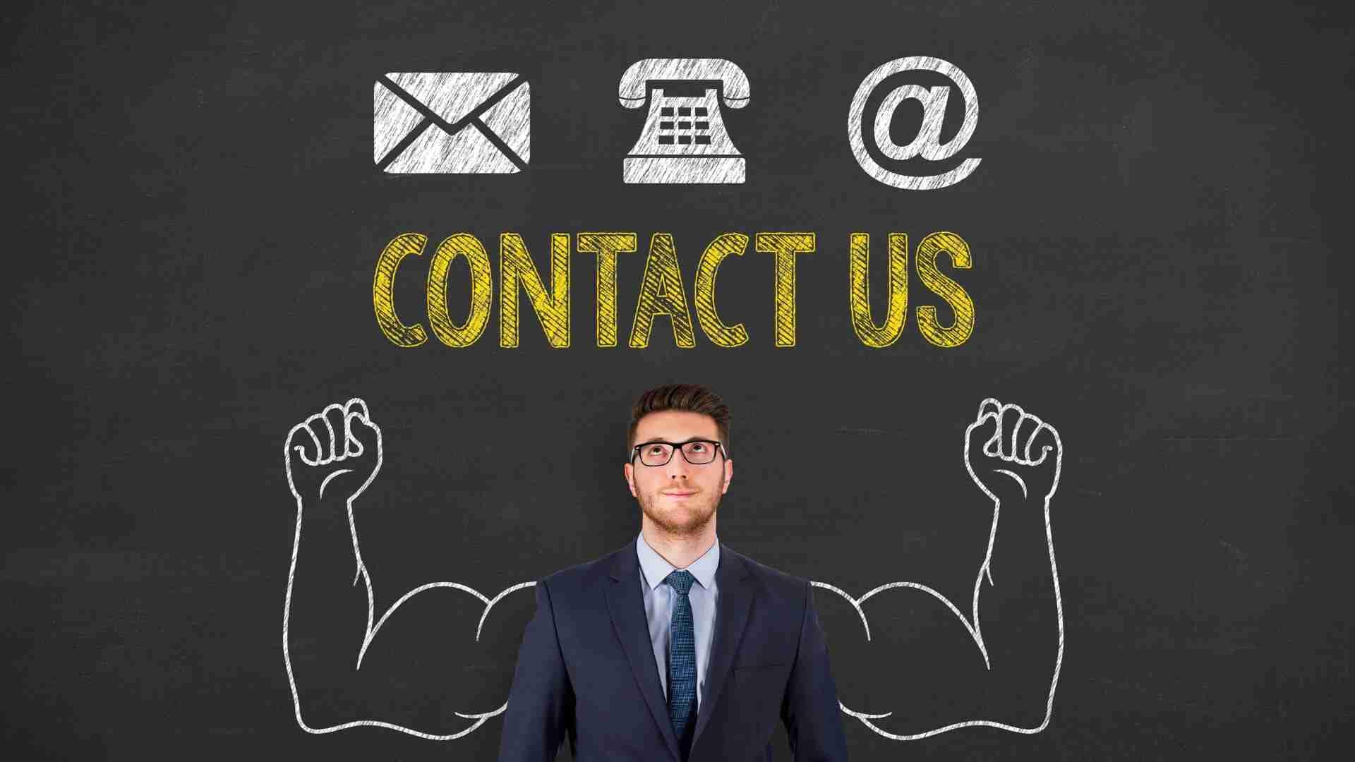 Mann in Anzug steht vor einer Tafel mit den Worten 'Kontaktieren Sie uns' und Symbolen für E-Mail, Telefon und @.