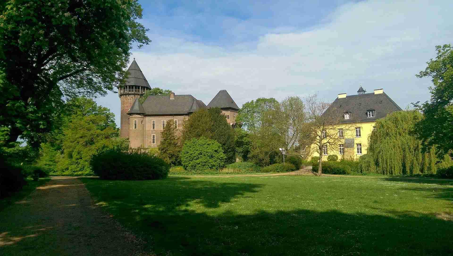 Burg Linn in Krefeld mit historischer Architektur und umgebendem Grün.