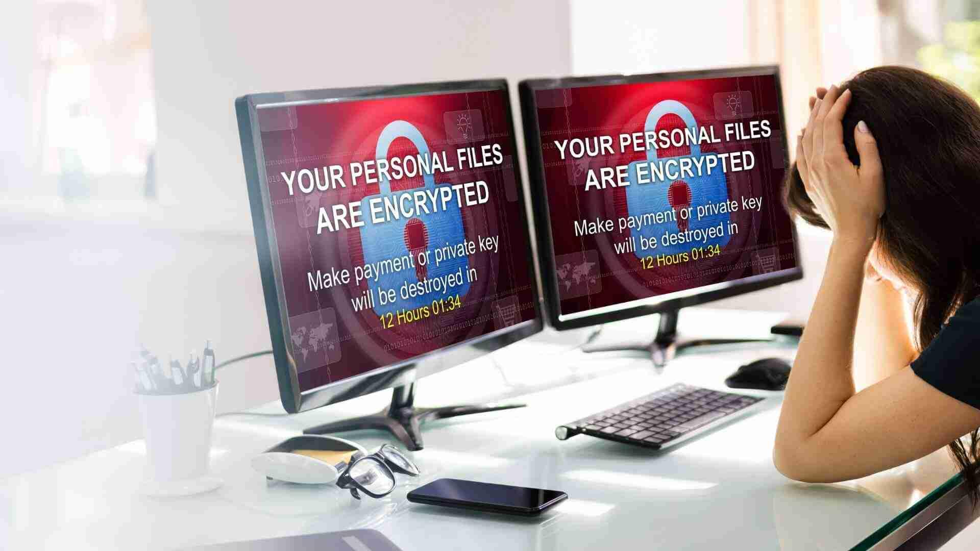 Zwei Computerbildschirme zeigen eine Ransomware-Nachricht mit verschlüsselten Dateien und Zahlungsaufforderung.